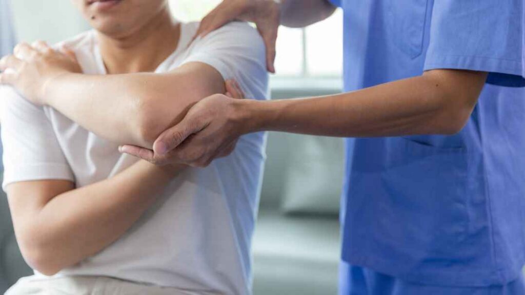 Un homme se fait examiner le bras par un médecin.
